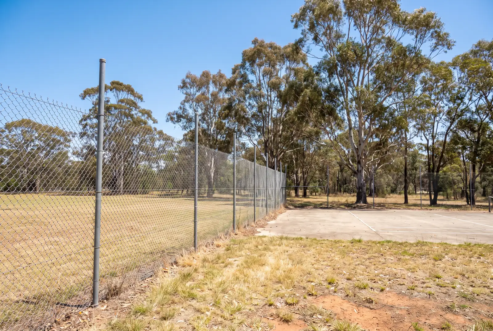 Galvanised chainwire fence around a sporting field