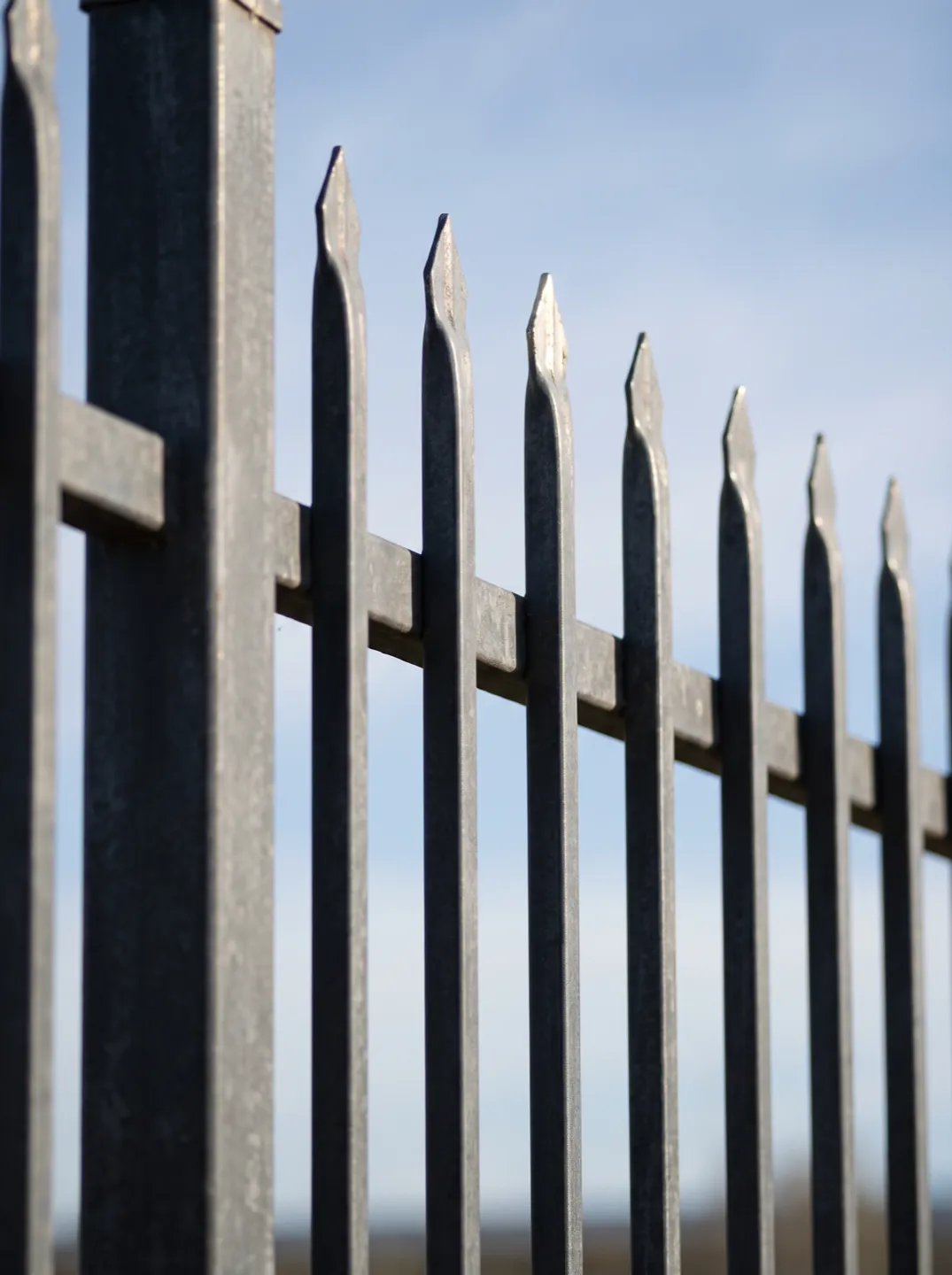Close-up of galvanised steel spear-top pickets