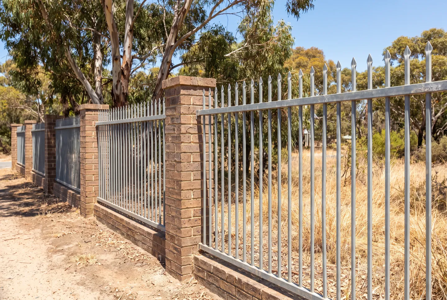 Press-formed spear-top steel fence at a property frontage
